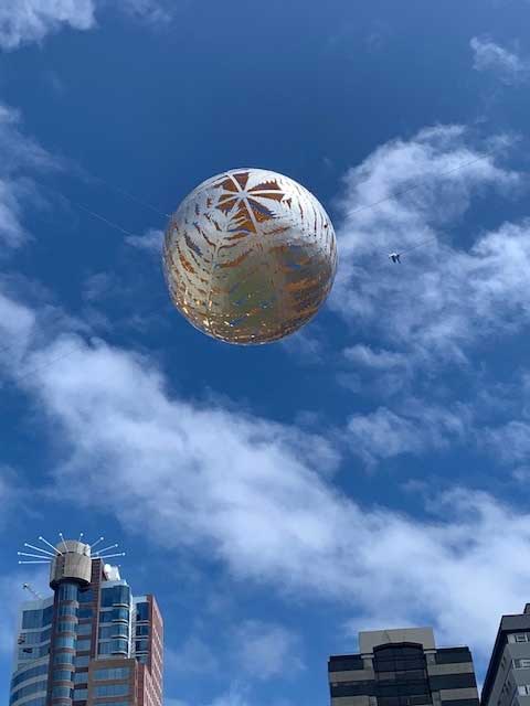 The silver nikau palm sculpture rising over Wellington against a bright sky